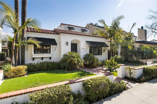 mediterranean / spanish-style house featuring a front lawn