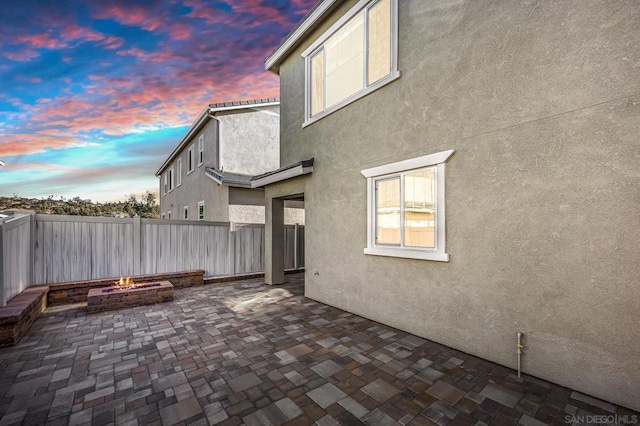 patio terrace at dusk featuring an outdoor fire pit