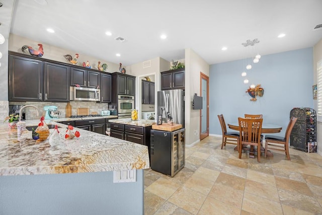 kitchen featuring sink, butcher block countertops, a center island, appliances with stainless steel finishes, and decorative backsplash