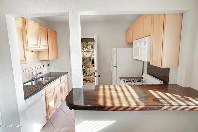 kitchen featuring sink, light tile patterned floors, light brown cabinets, white appliances, and backsplash