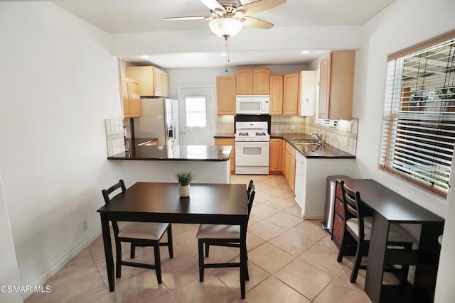 kitchen with sink, white appliances, a wealth of natural light, and light brown cabinets