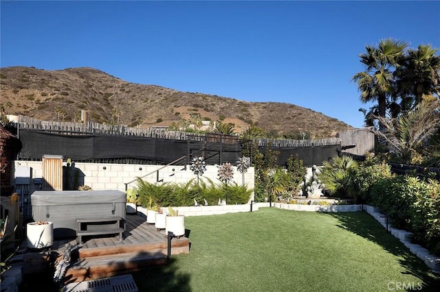 view of yard featuring a hot tub and a mountain view