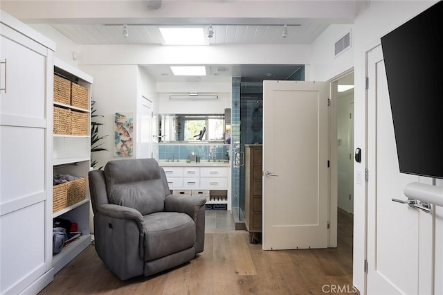 living area with wood ceiling, hardwood / wood-style flooring, and beamed ceiling