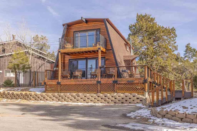 view of front of property featuring a wooden deck and a balcony