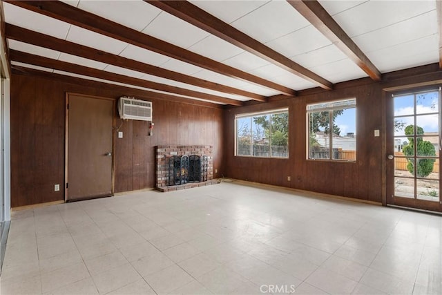 unfurnished living room featuring beamed ceiling, a wall mounted AC, a fireplace, and wood walls