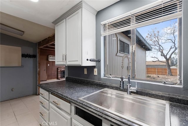 kitchen featuring white cabinetry, light tile patterned floors, and sink