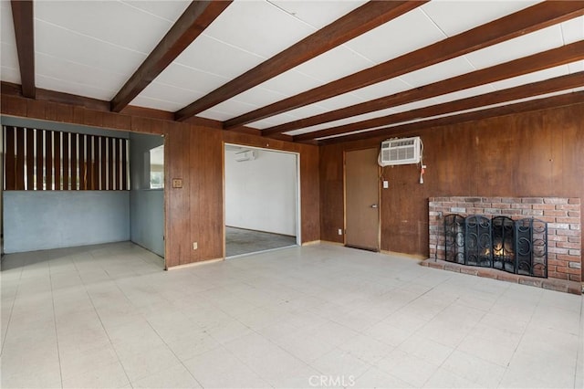 unfurnished living room featuring a wall unit AC, a fireplace, beam ceiling, and wood walls