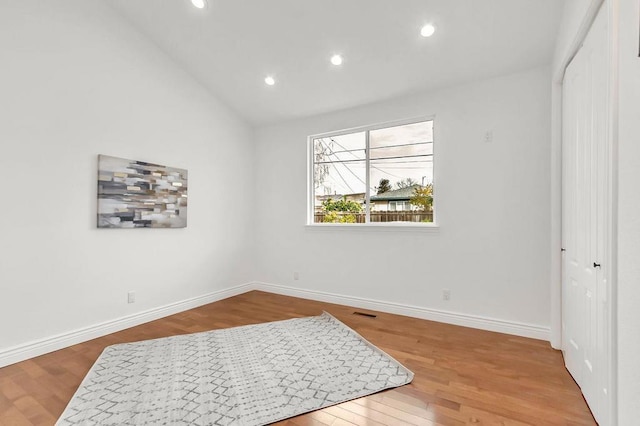 bedroom with lofted ceiling, wood-type flooring, and a closet