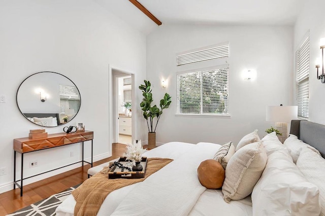 bedroom with hardwood / wood-style flooring, high vaulted ceiling, ensuite bath, and beamed ceiling