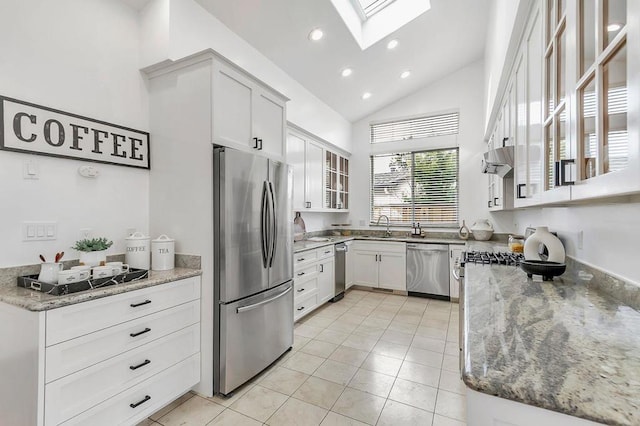 kitchen with stainless steel appliances, sink, white cabinets, and light stone counters