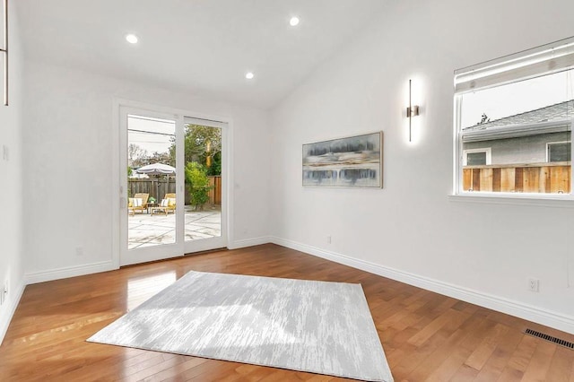 interior space with hardwood / wood-style flooring and vaulted ceiling