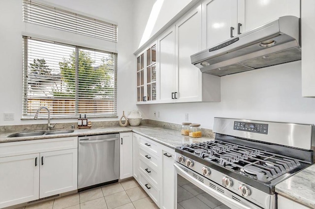 kitchen with appliances with stainless steel finishes, light stone countertops, sink, and white cabinets