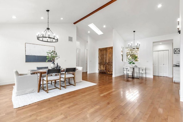 dining space featuring beam ceiling, high vaulted ceiling, hardwood / wood-style floors, and a chandelier