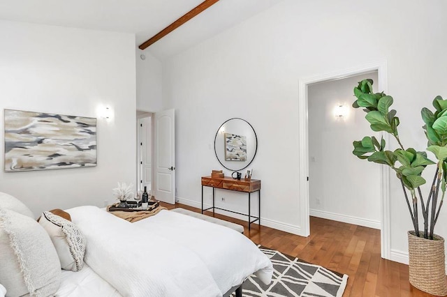 bedroom with beamed ceiling, wood-type flooring, and high vaulted ceiling