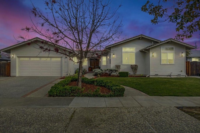 ranch-style house featuring a garage and a yard