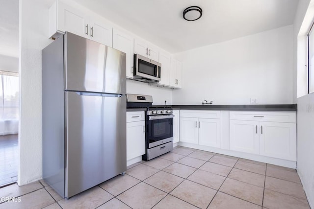 kitchen featuring white cabinetry, appliances with stainless steel finishes, and light tile patterned flooring