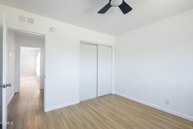 unfurnished bedroom featuring light hardwood / wood-style flooring, a closet, and ceiling fan