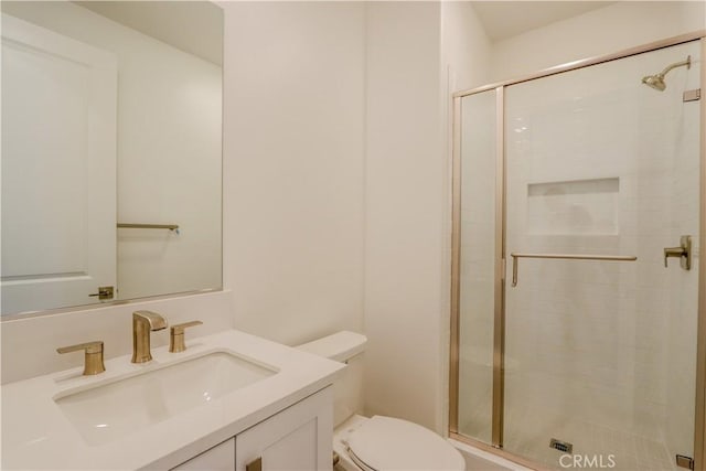 bathroom with a shower with door, vanity, and toilet