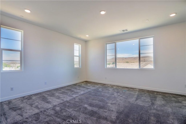 unfurnished room with dark colored carpet