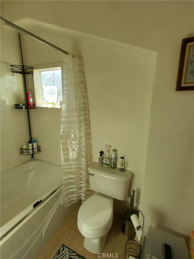 bathroom with hardwood / wood-style flooring, shower / bathtub combination with curtain, and toilet