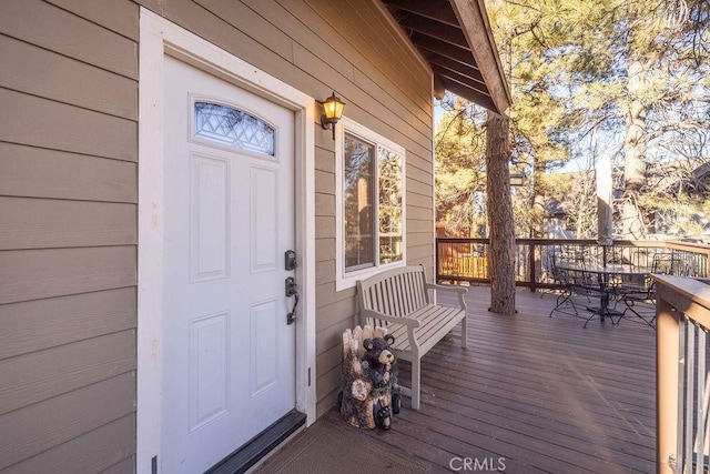 view of exterior entry featuring a wooden deck