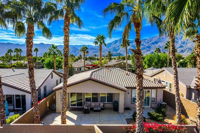 exterior space with outdoor lounge area, a mountain view, and a patio