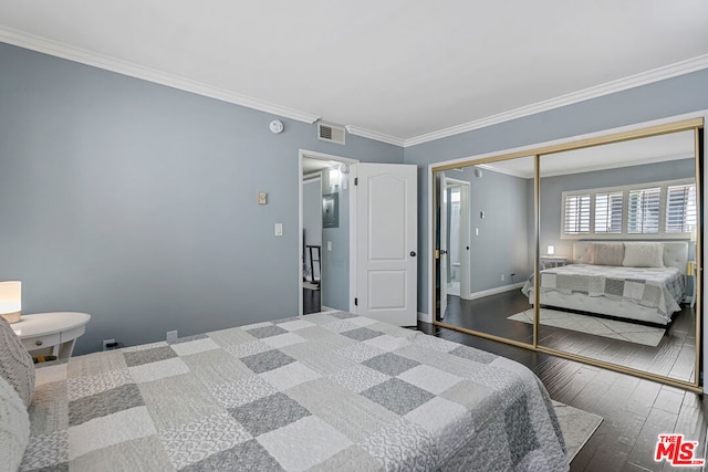 bedroom with dark hardwood / wood-style floors, ornamental molding, and a closet