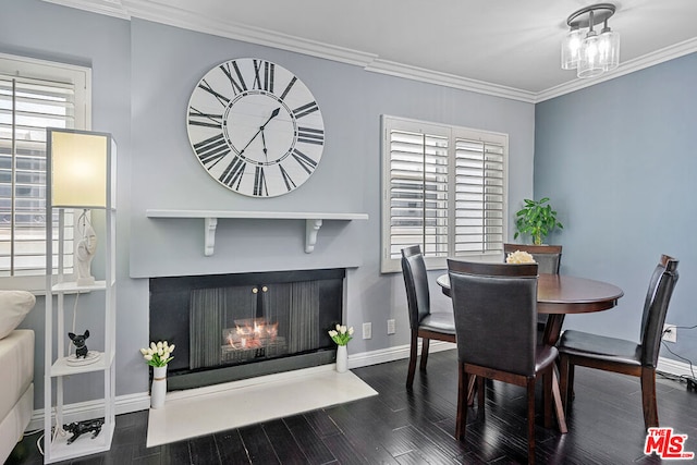 dining area with dark wood-type flooring, a wealth of natural light, and ornamental molding