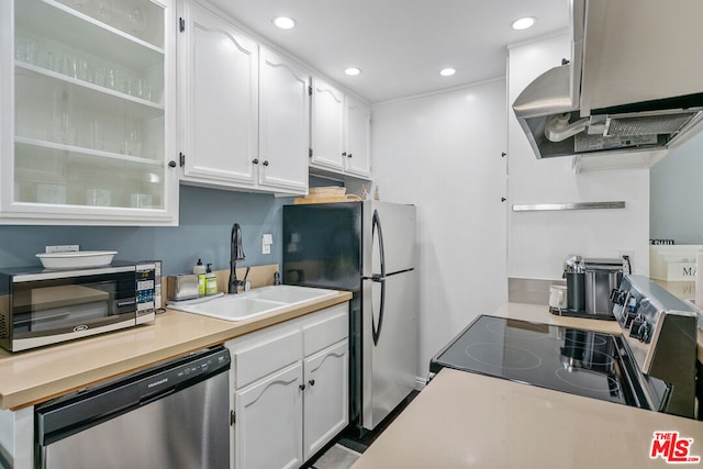 kitchen featuring stainless steel appliances, white cabinetry, sink, and island exhaust hood