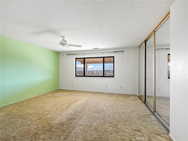 interior space featuring ceiling fan, carpet floors, and a textured ceiling