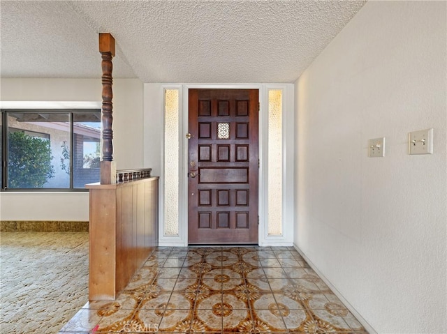 entrance foyer featuring a textured ceiling and light tile patterned flooring