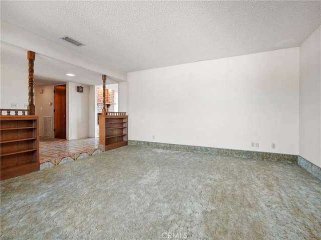 carpeted spare room with a textured ceiling