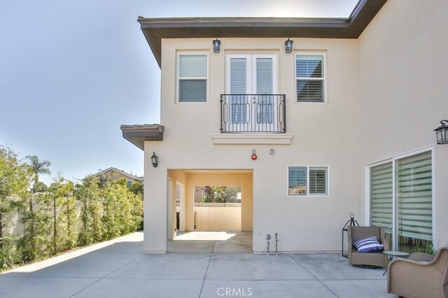 rear view of house with a balcony and a patio