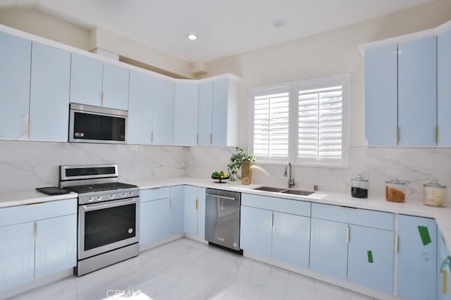 kitchen featuring tasteful backsplash, appliances with stainless steel finishes, light countertops, and a sink