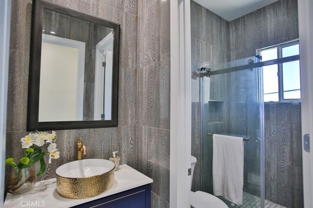 bathroom with an enclosed shower, vanity, and toilet