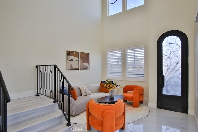 foyer entrance featuring stairway, a high ceiling, and baseboards