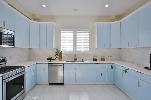 kitchen featuring stainless steel appliances, marble finish floor, light countertops, and a sink