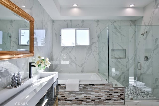 bathroom featuring a stall shower, vanity, a washtub, and recessed lighting