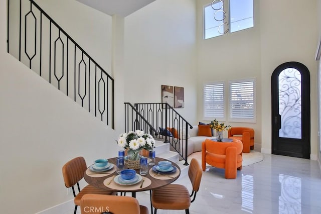 entrance foyer with a towering ceiling, stairs, baseboards, and a wealth of natural light