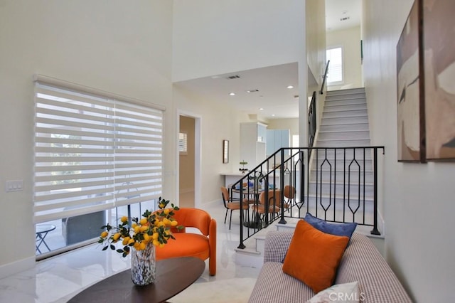 interior space featuring recessed lighting, baseboards, stairway, and a high ceiling