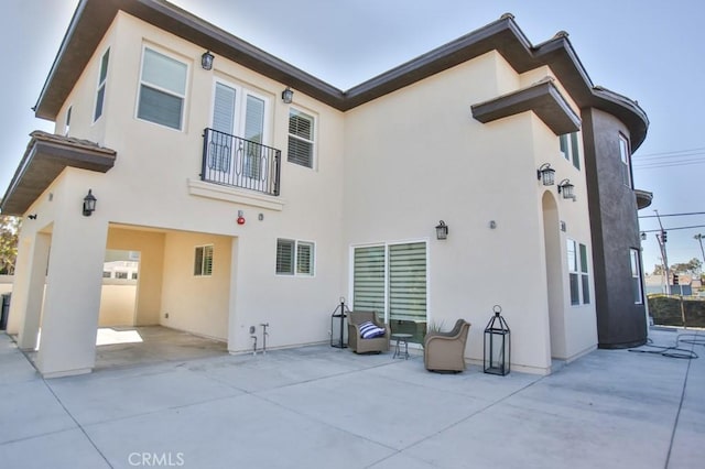 rear view of property featuring a patio area and stucco siding