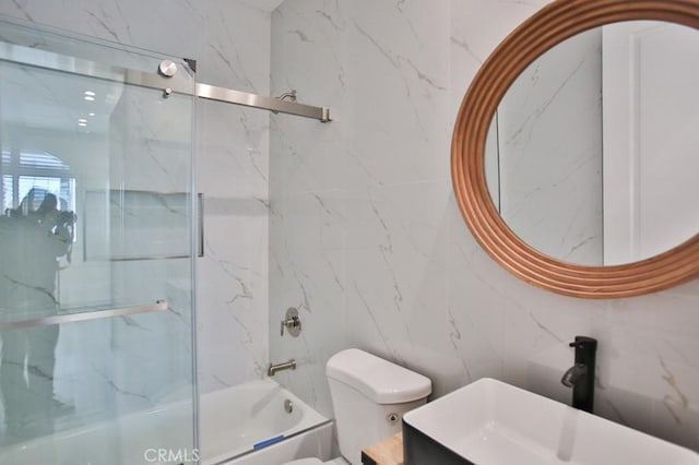 full bathroom with combined bath / shower with glass door, vanity, and toilet