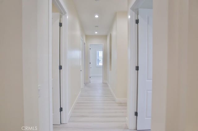 hall featuring light wood-style floors, recessed lighting, and baseboards