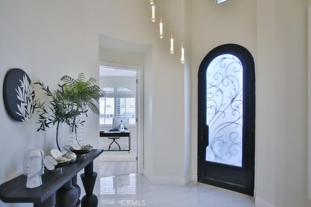 foyer entrance featuring marble finish floor and baseboards