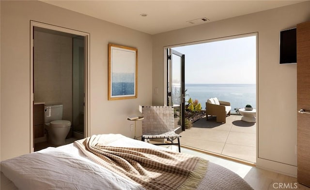 bedroom featuring a water view, ensuite bath, and light hardwood / wood-style floors