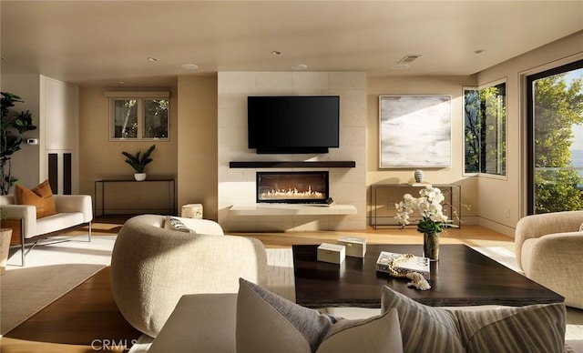 living room featuring a tiled fireplace and light hardwood / wood-style flooring