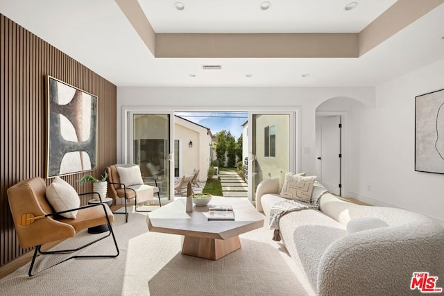 living room with light colored carpet and wooden walls