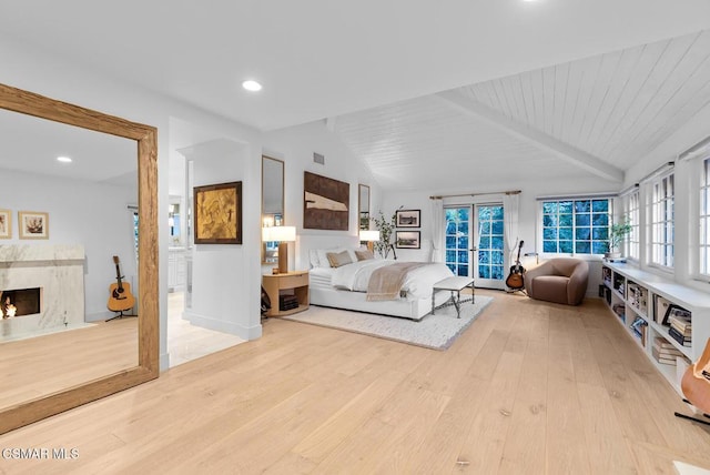 bedroom with light hardwood / wood-style flooring, wood ceiling, a fireplace, and lofted ceiling with beams