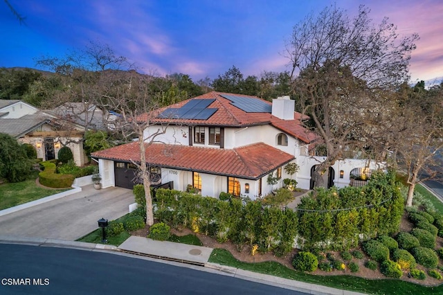 mediterranean / spanish-style house featuring a garage and solar panels