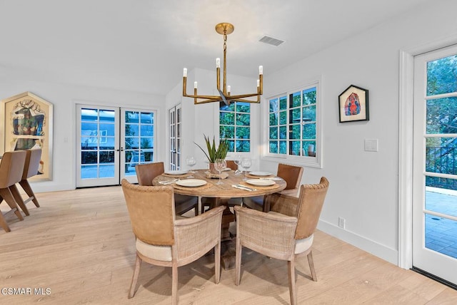 dining area featuring french doors, a chandelier, and light hardwood / wood-style flooring